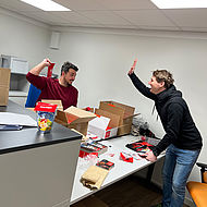 Zwei Mitarbeiter der Franz Mayer Maler- und Lackierwerkstätten beim Verpacken der Give-aways für den Handwerker-Azubi-Tag 2023 in Nürnberg